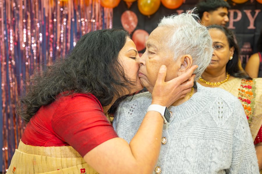 A loving kiss at a 90th birthday celebration