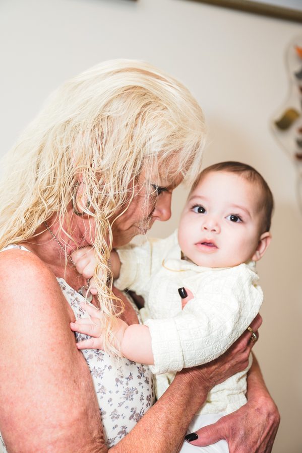 A grandmother holding her grandson after his baptism