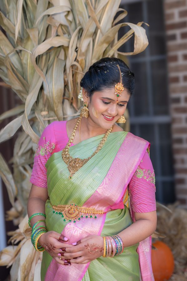 Portrait of a mother-to-be in a pink and green silk saree